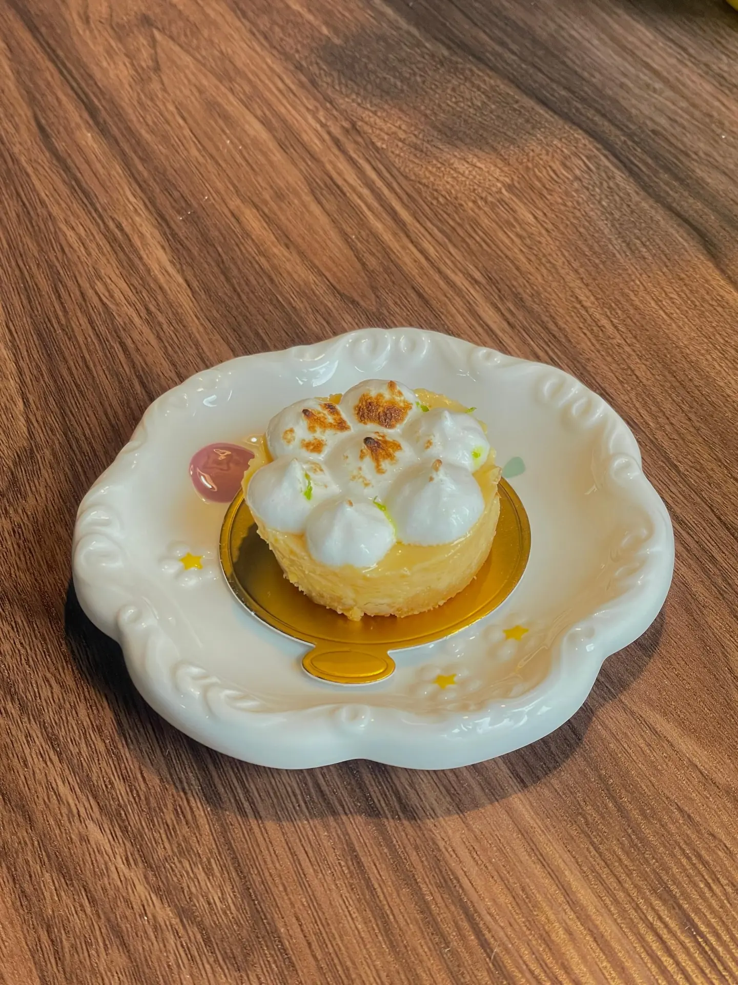 Zitronentörtchen mit Meringue auf einem verzierten Teller