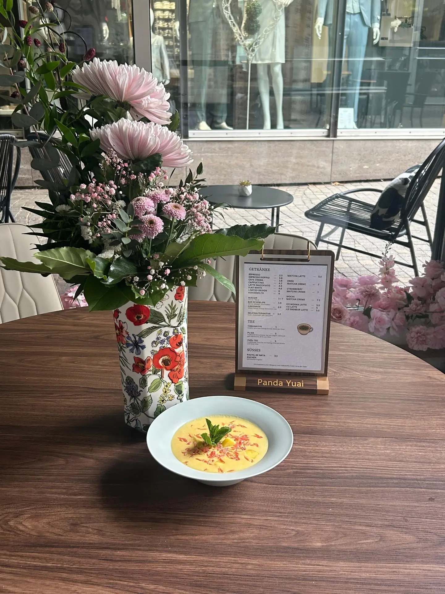 Mango-Dessert und Speisekarte auf der Terrasse in der Fußgängerzone